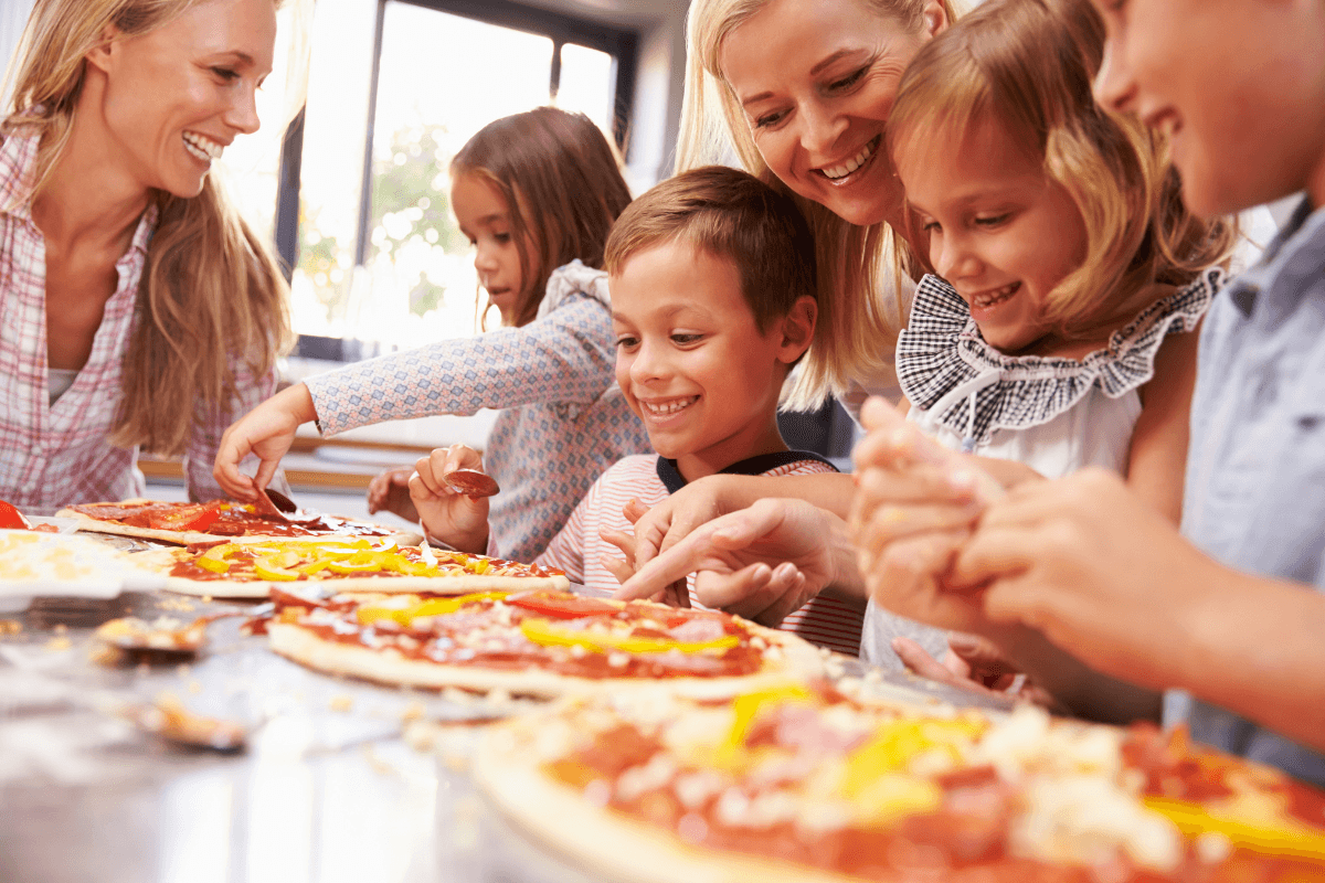 Kids making pizza together at a cooking class